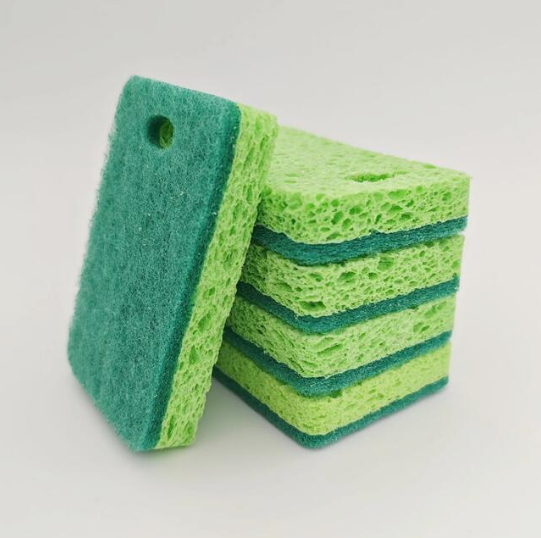 Green sponge in use for kitchen cleaning