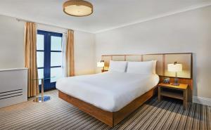 China Budget Hotel Bedroom Furniture Leather bed with Leisure chairs and Wood TV Stand Cabinets factory