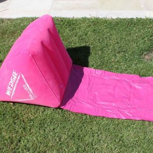 Inflatable wedge-shaped lounger cushion with a waterproof mat