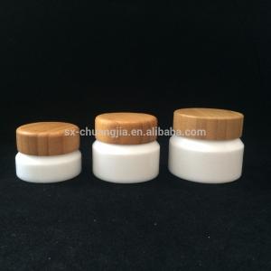 China New products 15ml 30ml 50ml 100ml opal white cream glass jar with bamboo screw cap factory