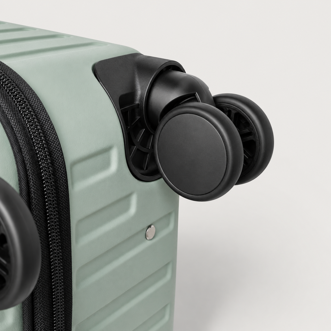 Close-up of paired suitcase spinner wheels and corner housing